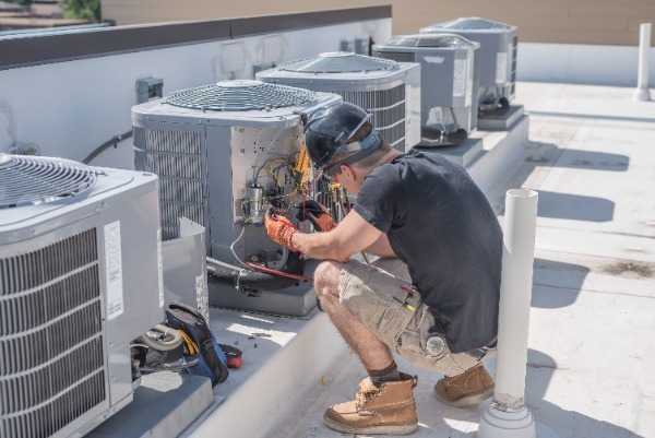 Man Fixing Condenser On Unit
